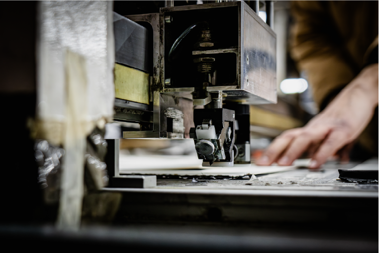 Industrial cutting machine operator hand shallow depth of field